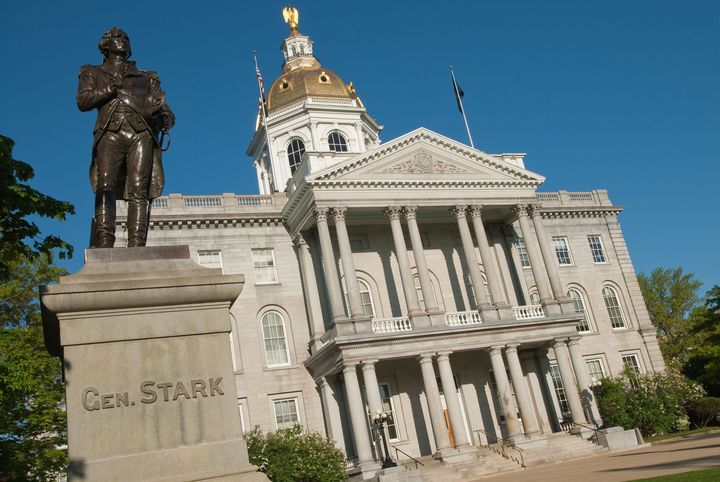 Statue of Clara Stark in front of a neoclassical courthouse with a gold dome under a blue sky