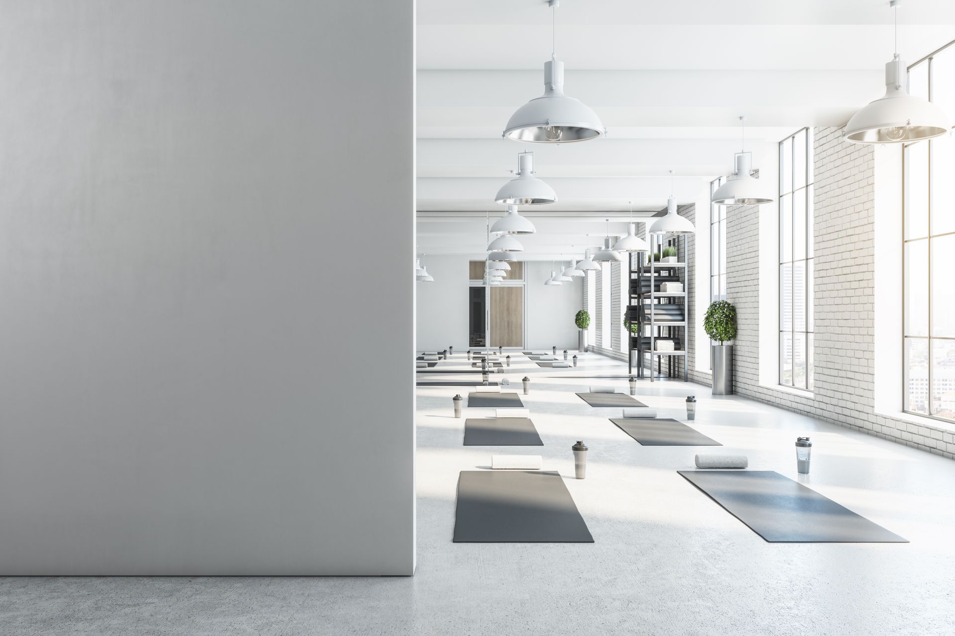 There are many yoga mats in this room with a lot of windows.