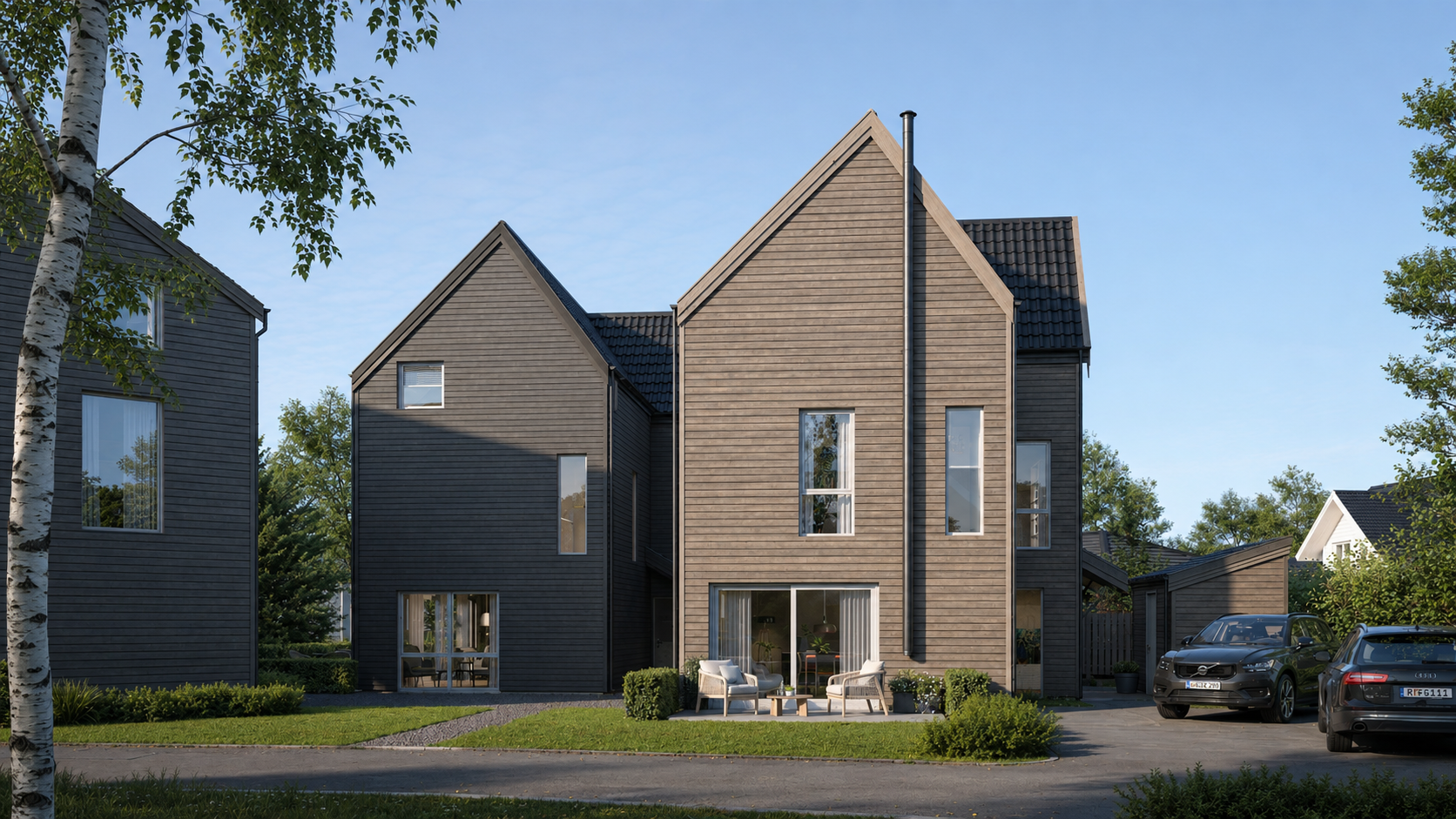 Moderne rekkehus med mørk treverkside og store vinduer under en blå himmel