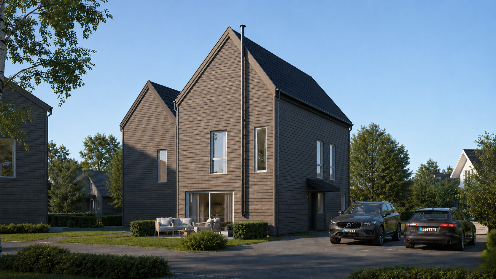Moderne toetasjes murhus med mørkt tak og parkerte biler i et forstadsområde