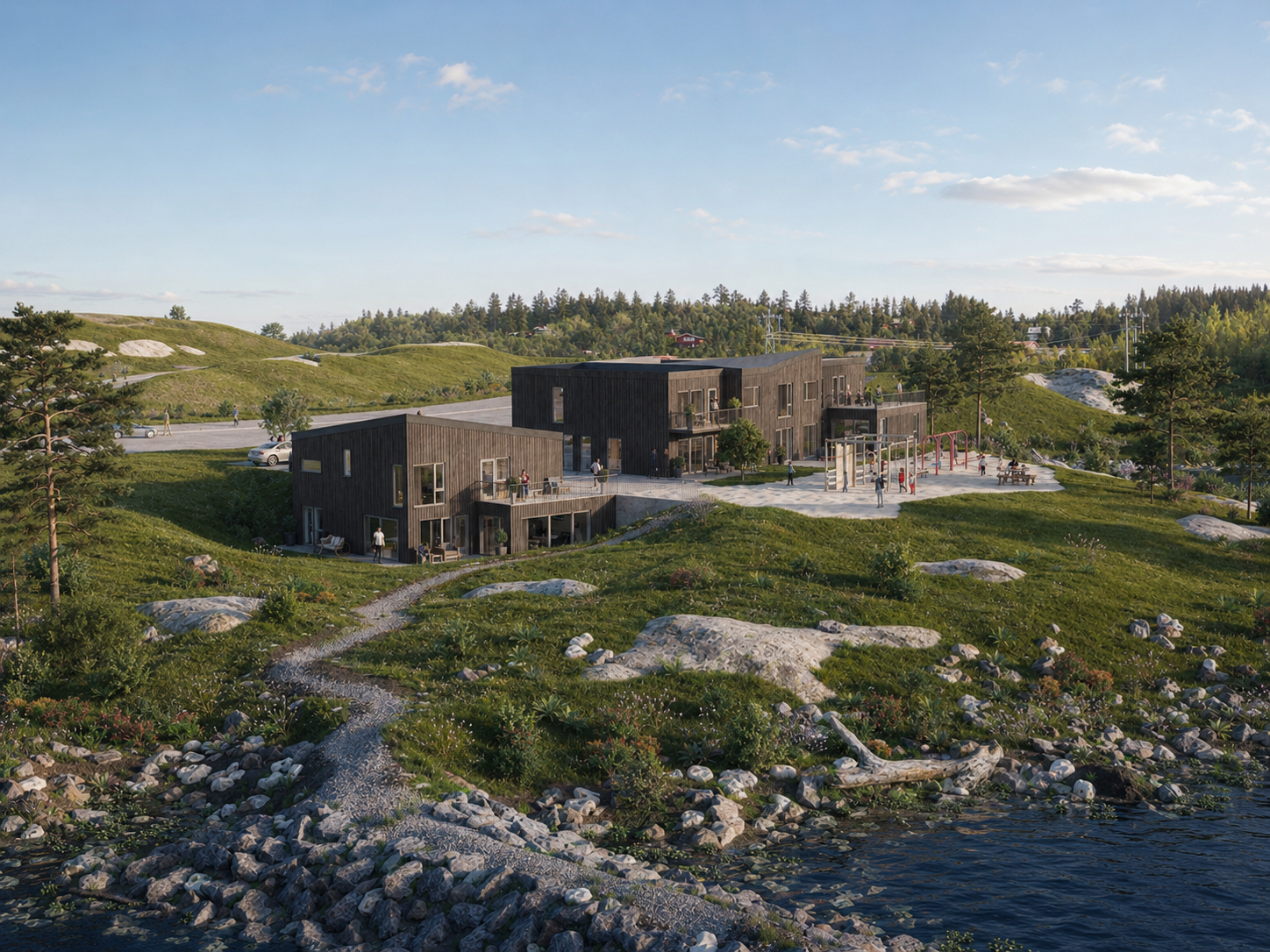 Flere hus på steinete kystlinje med gress, trær og rolig vann under en blå himmel