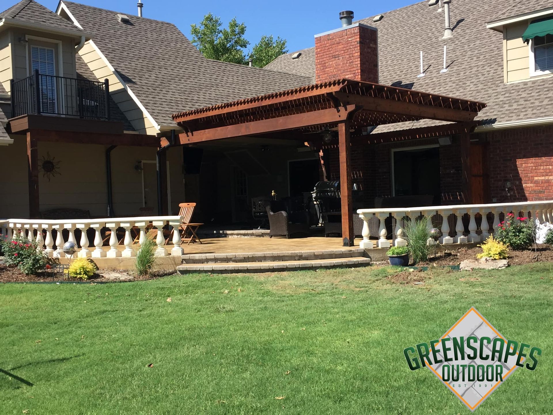A large house with a large lawn and a wooden porch.