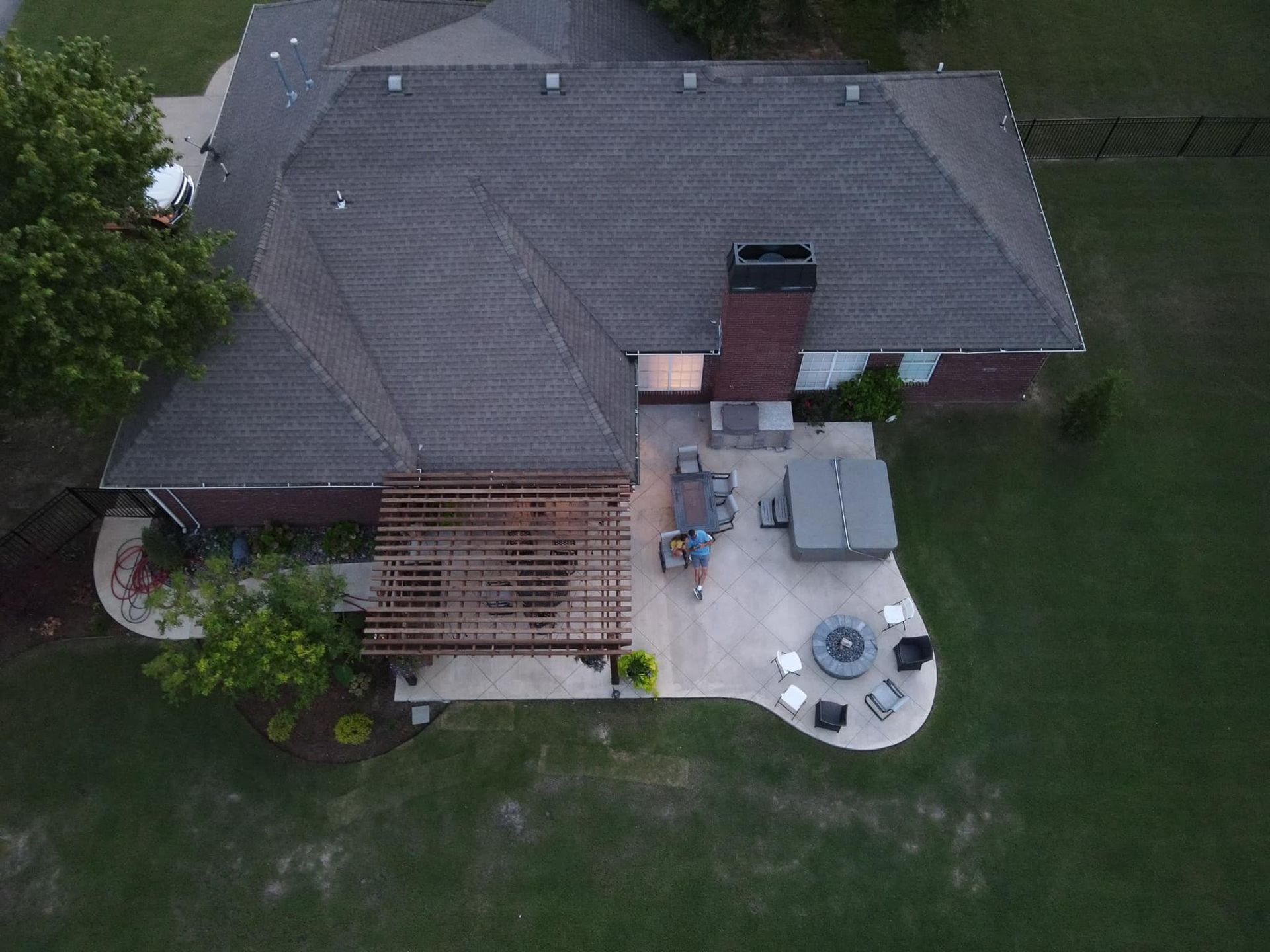 An aerial view of a house with a patio and a fire pit.