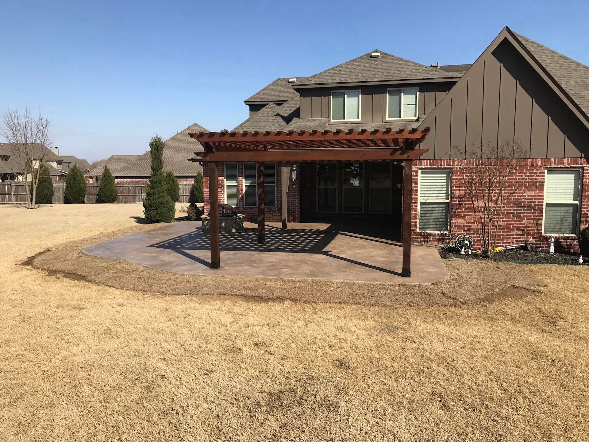 There is a pergola in the backyard of a house.