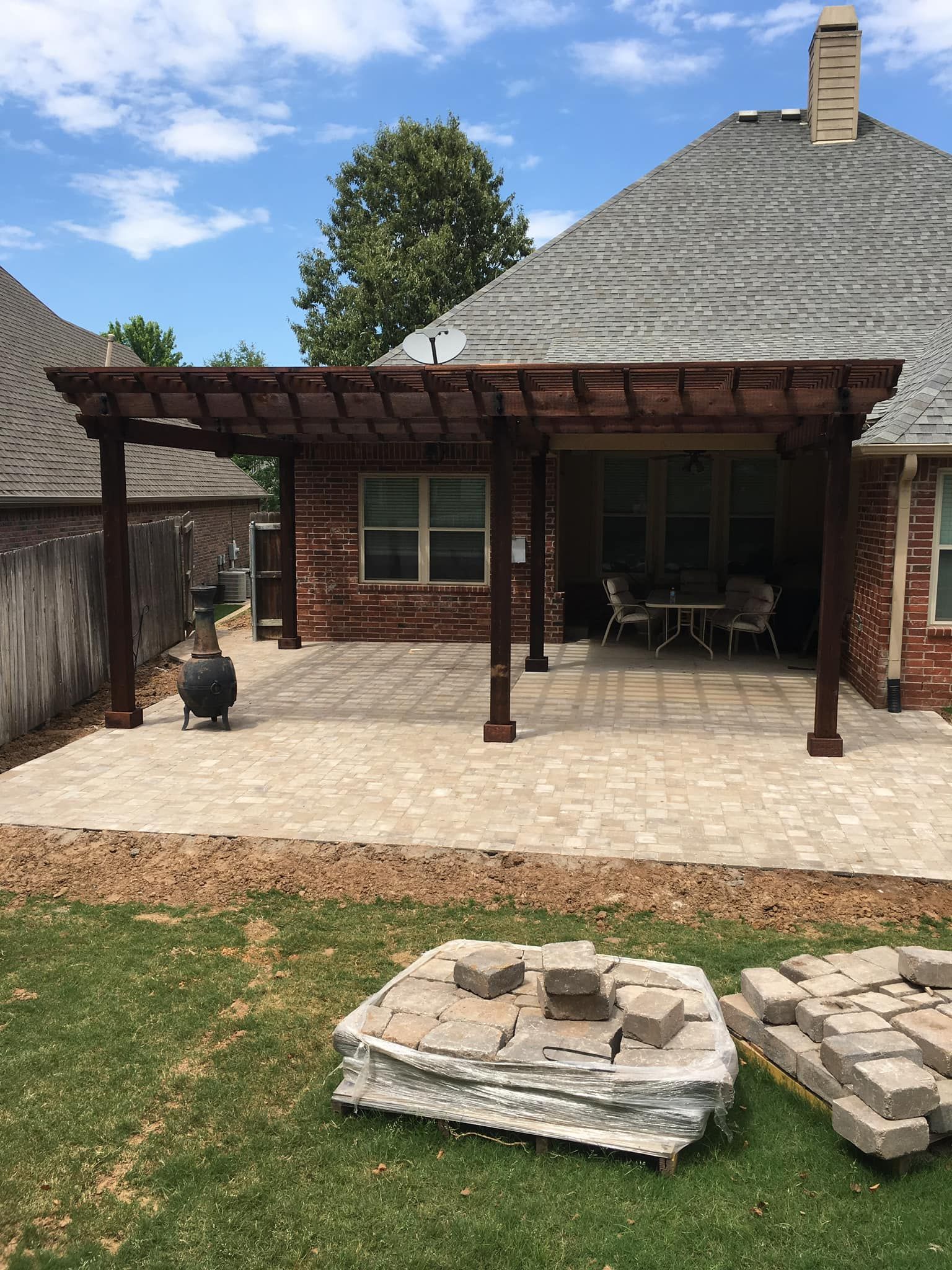 A pergola is being built in the backyard of a house.