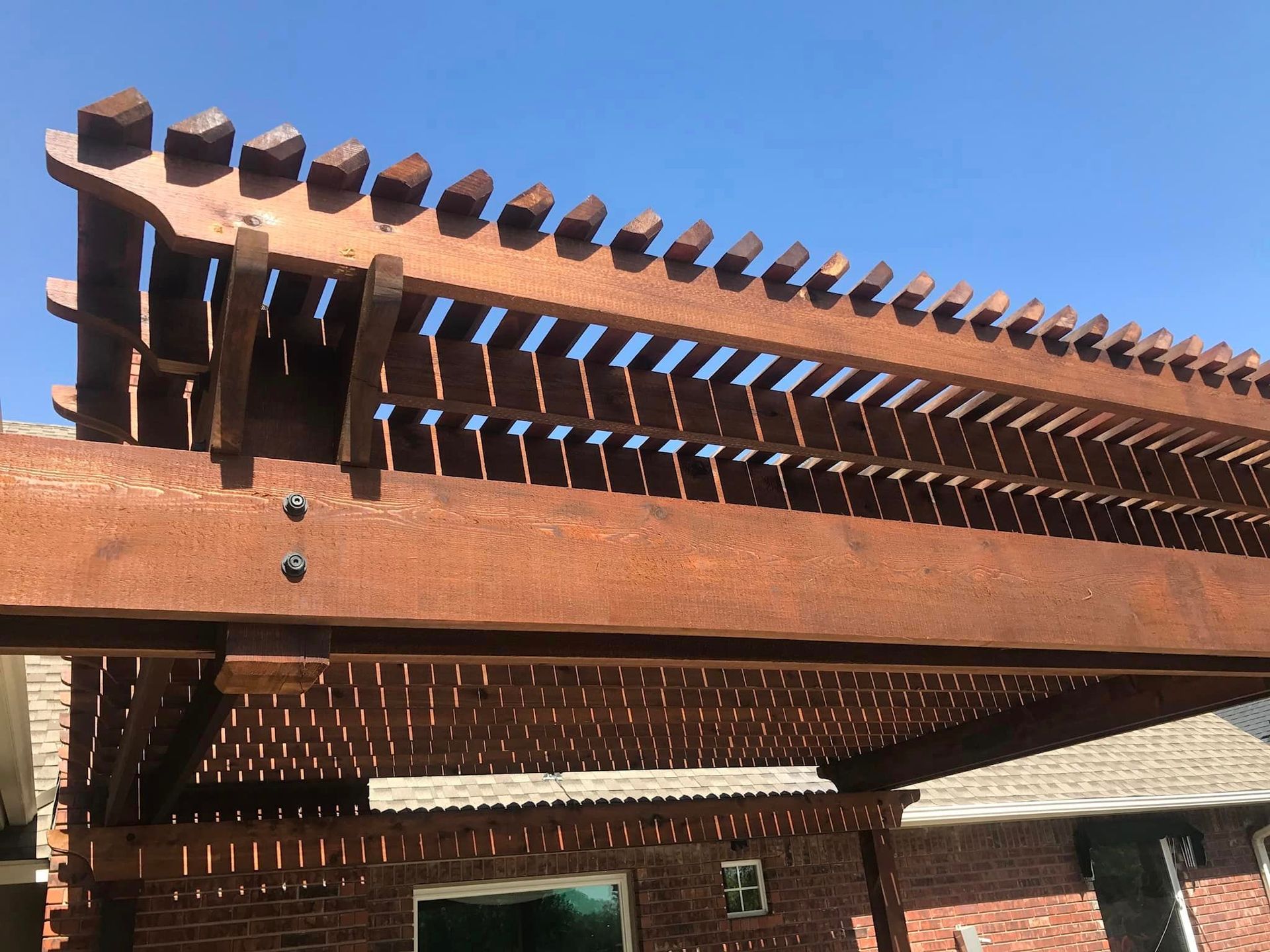 A wooden pergola with a blue sky in the background