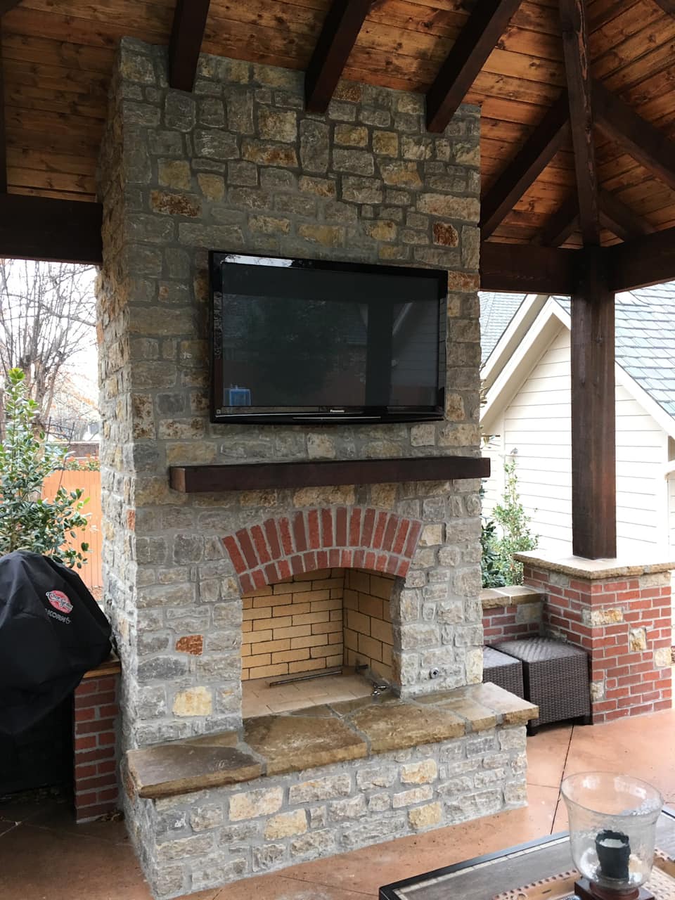 A brick fireplace with a flat screen tv mounted above it.