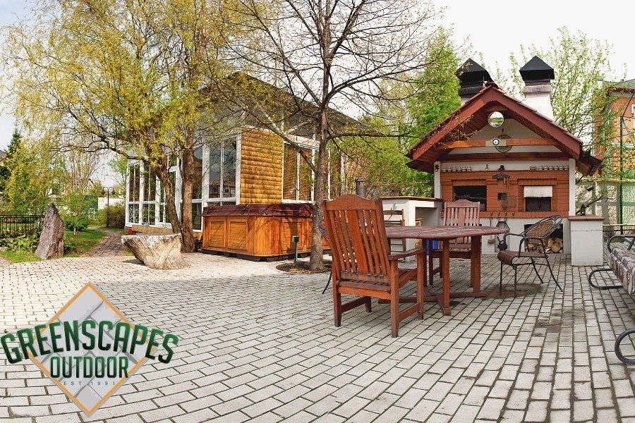 A patio with a table and chairs in front of a house.