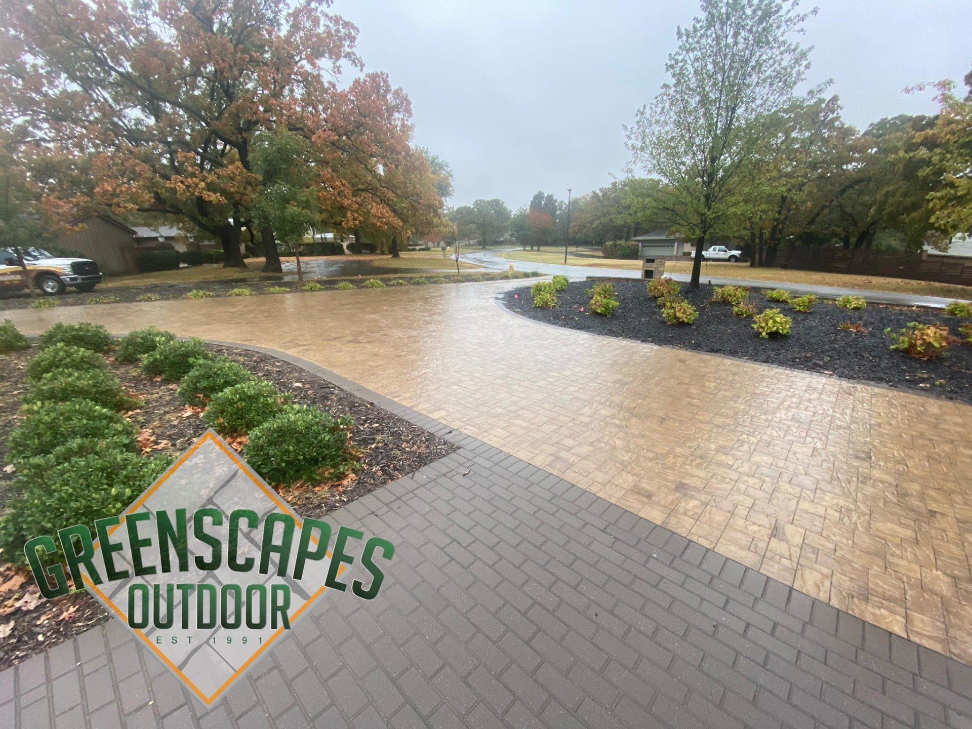 A brick walkway with a sign that says greenscapes outdoor