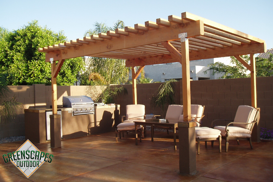 A patio with a pergola and a grill from greenscapes outdoor
