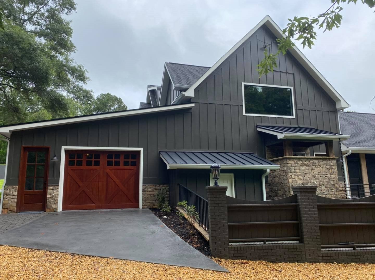 A large house with a garage and a fence in front of it.