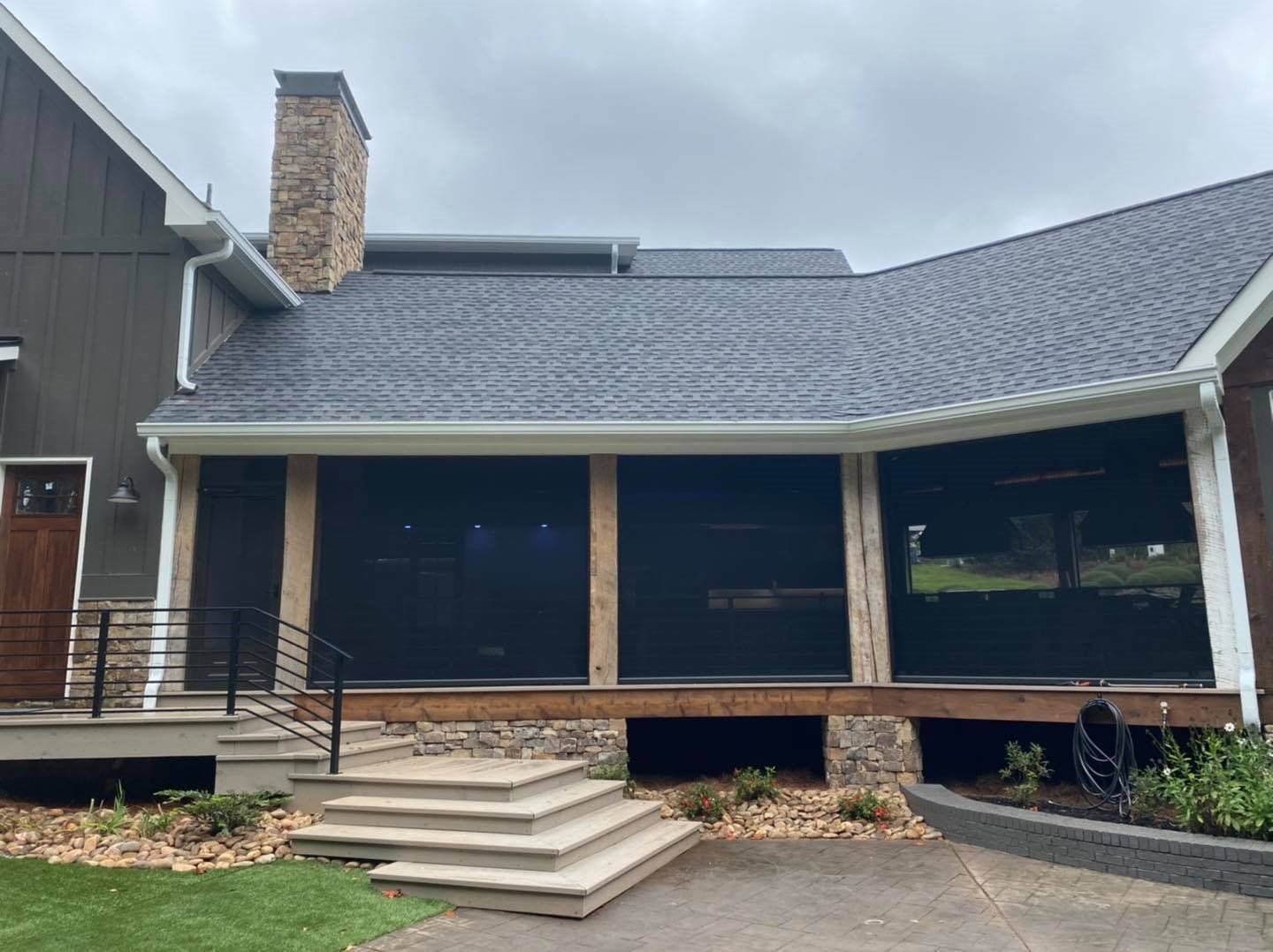 A large house with a screened in porch and stairs leading up to it.