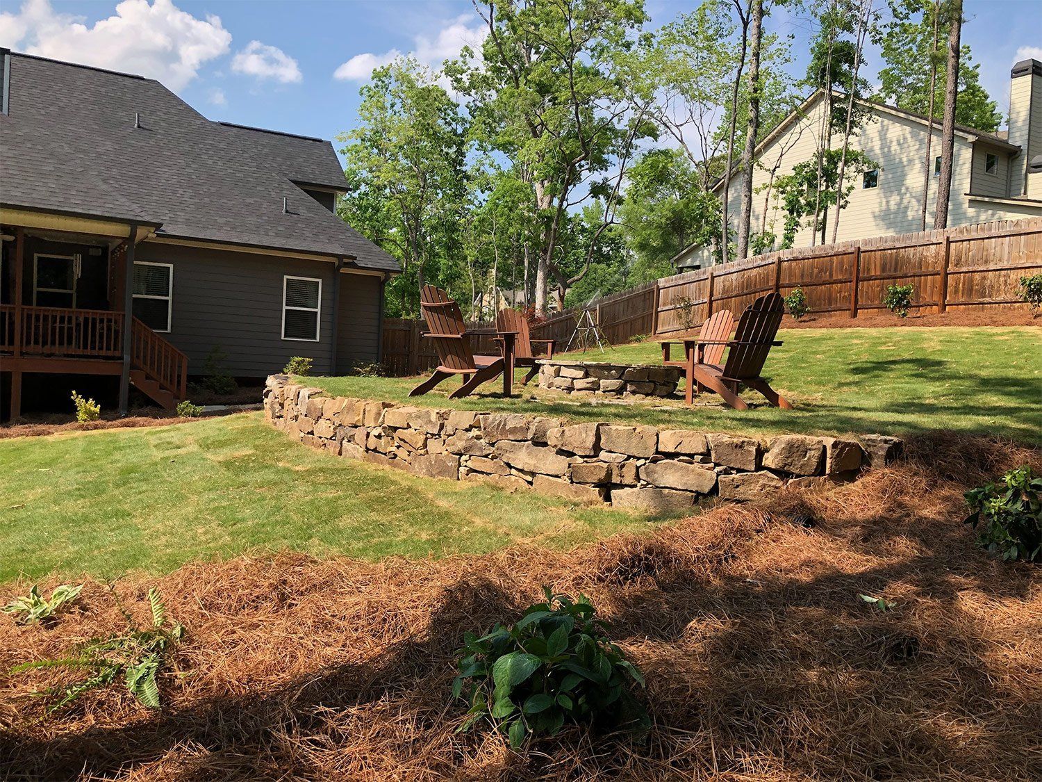There is a fire pit in the backyard of a house.