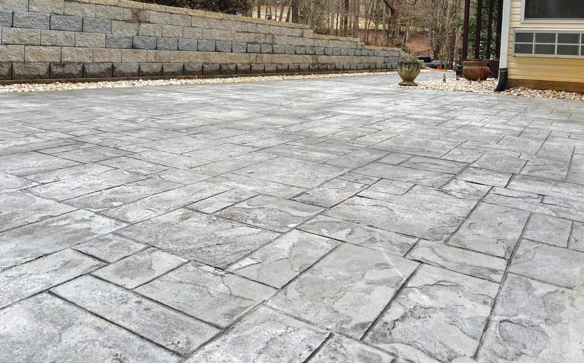 A concrete patio with a brick wall in the background.