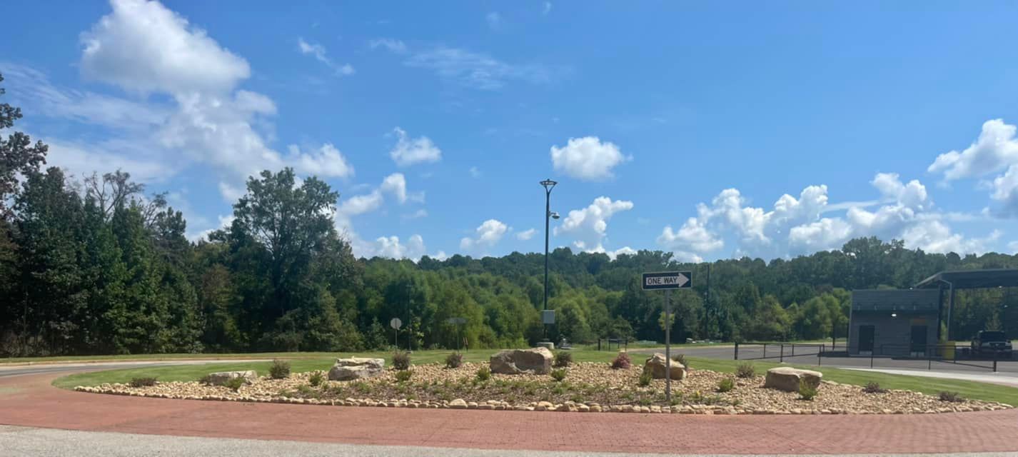 A park with trees in the background on a sunny day.