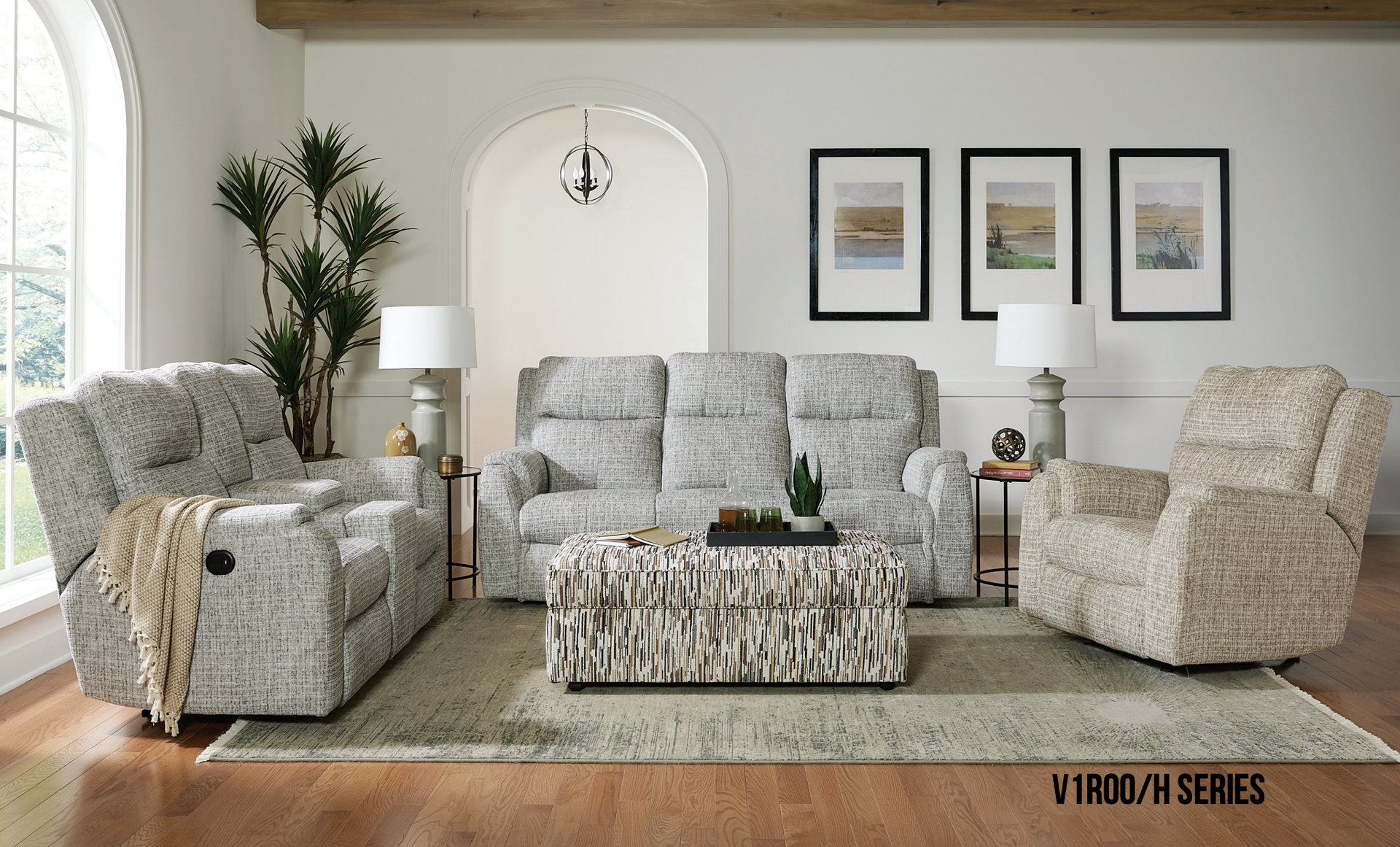 Living room with recliner, sofa, and chair in patterned fabric. Neutral colors, rug, artwork.