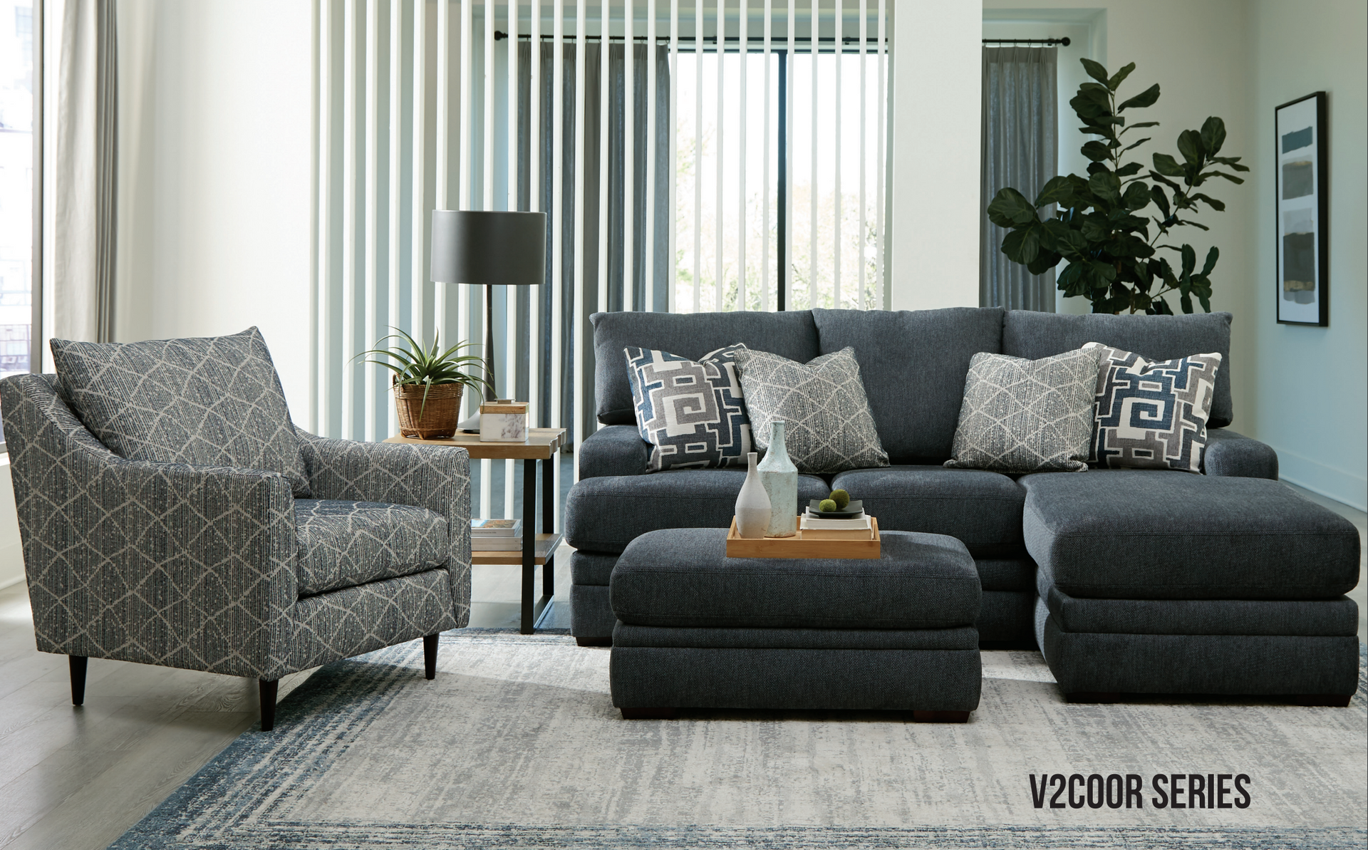Living room with gray sofa, patterned armchair, ottoman, side table, and rug.