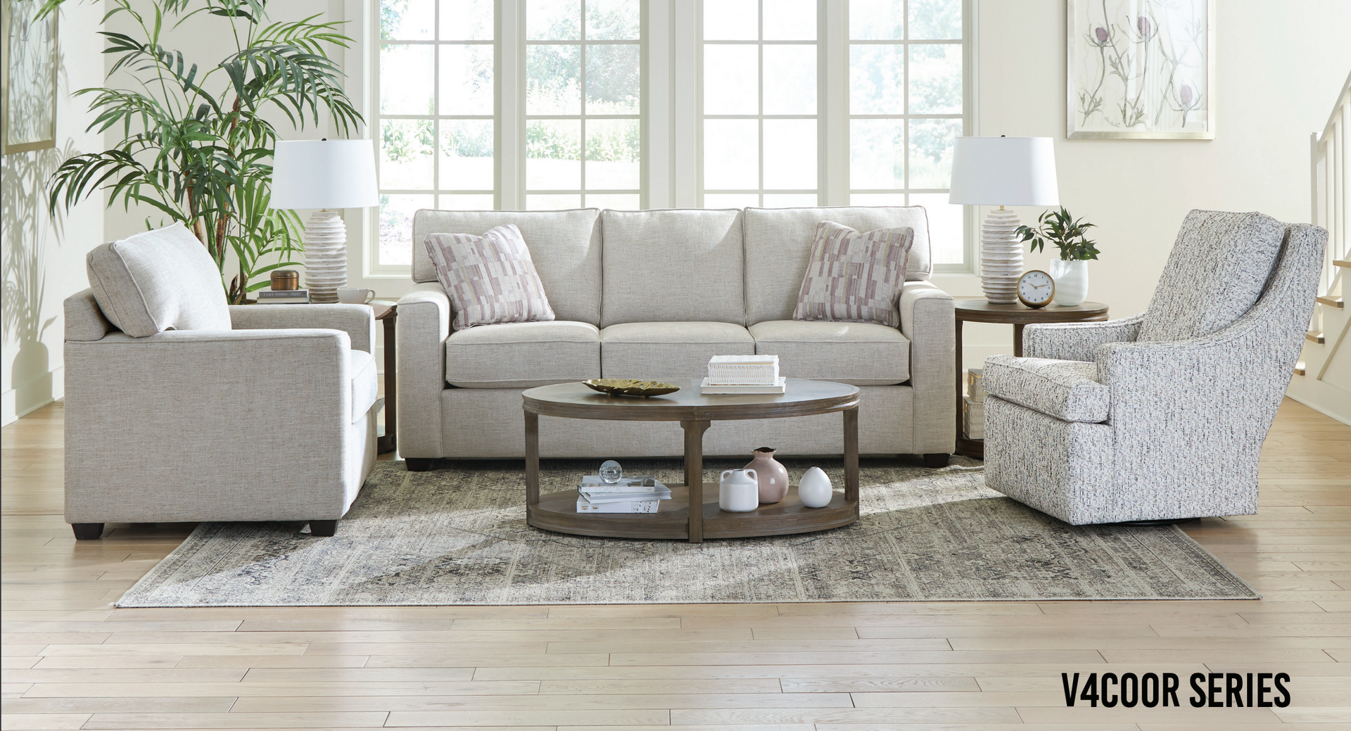 Living room with a sofa, two chairs, and a coffee table on a rug.