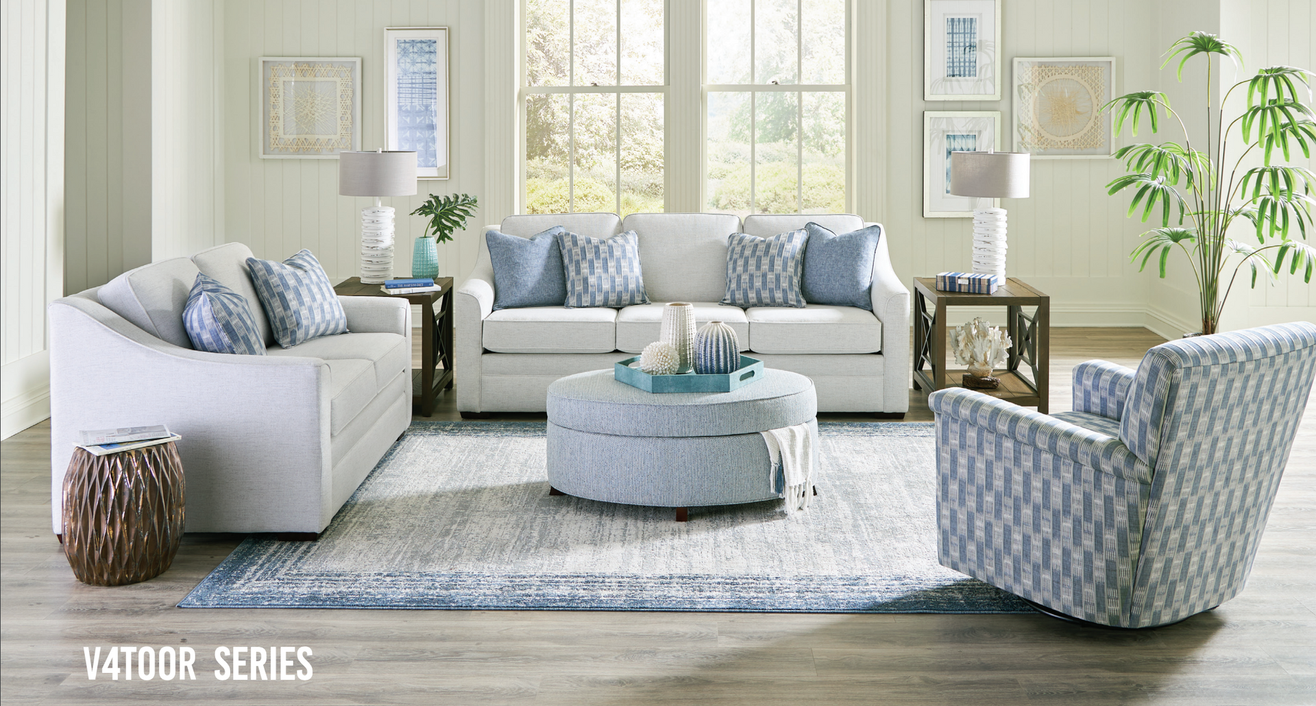 Living room with white sofas, blue accents, natural light, rug and decor.
