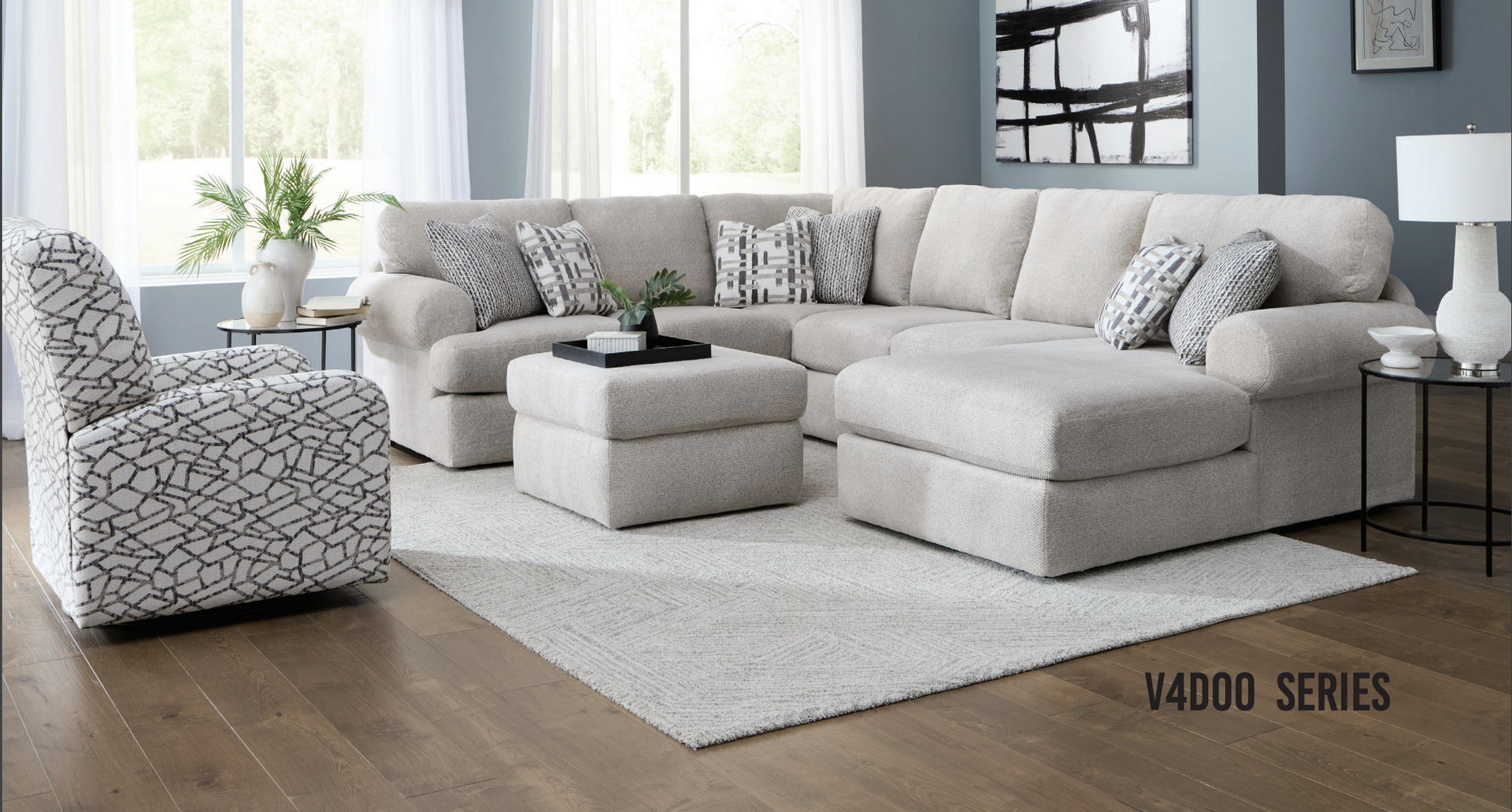 Beige sectional sofa and patterned armchair in a living room, with ottoman and rug.