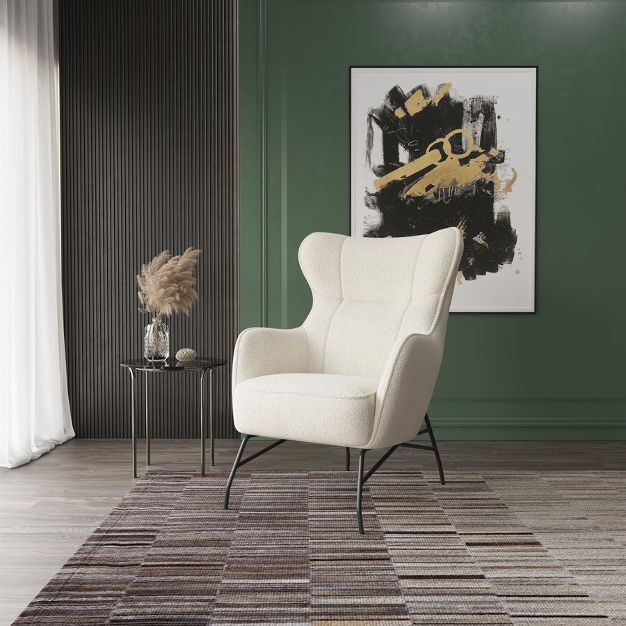 Cream armchair in a green room with abstract art and dark wood paneling.
