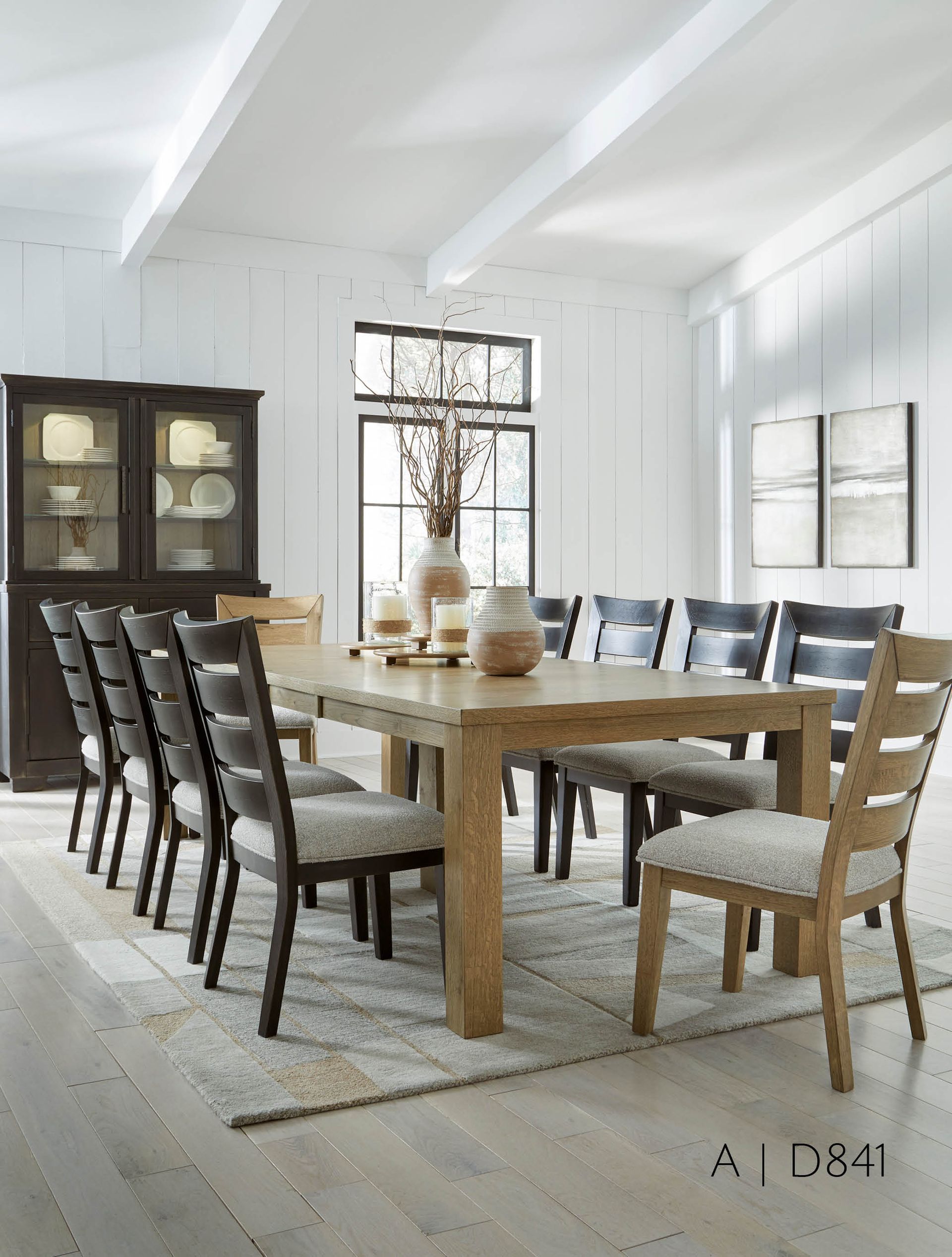 Dining room with large wood table, chairs, and hutch. Neutral color scheme.