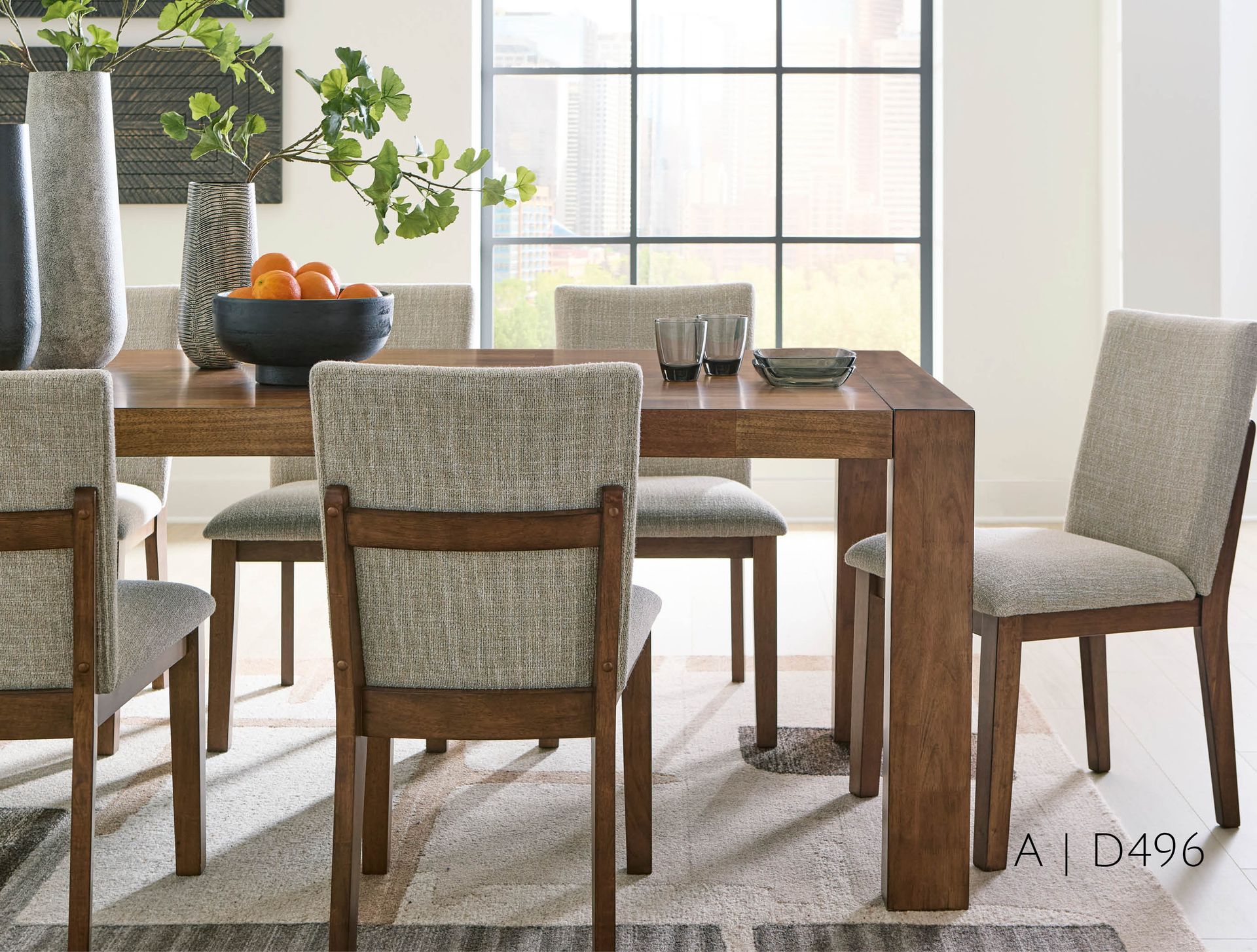 Dining room table set with six upholstered chairs, neutral colors, and natural light.