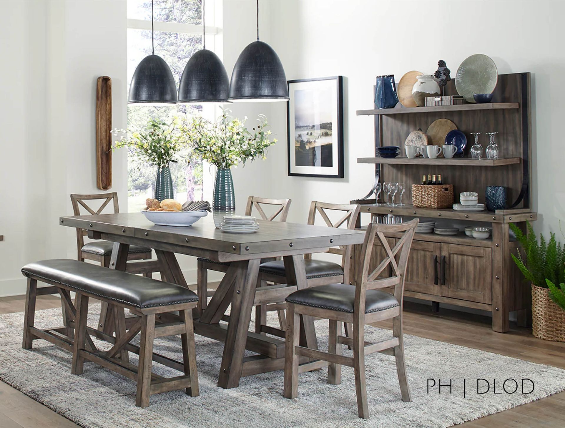 Rustic dining room set: gray wooden table and chairs, leather bench, hutch with decor