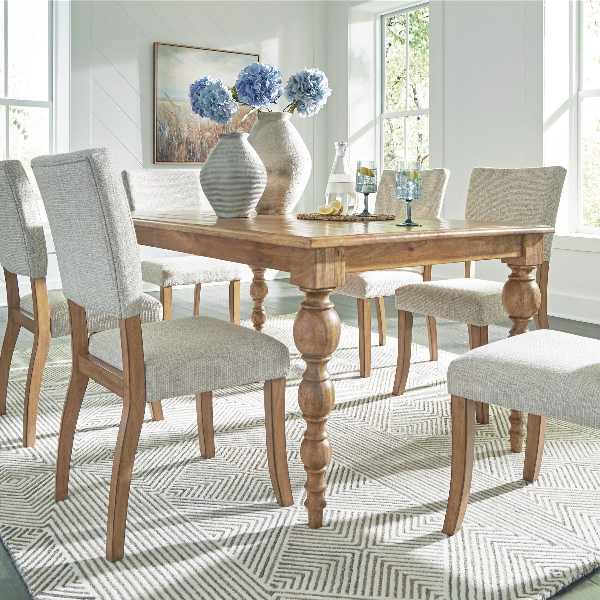Dining room set: wooden table, six upholstered chairs, vases with flowers, rug.