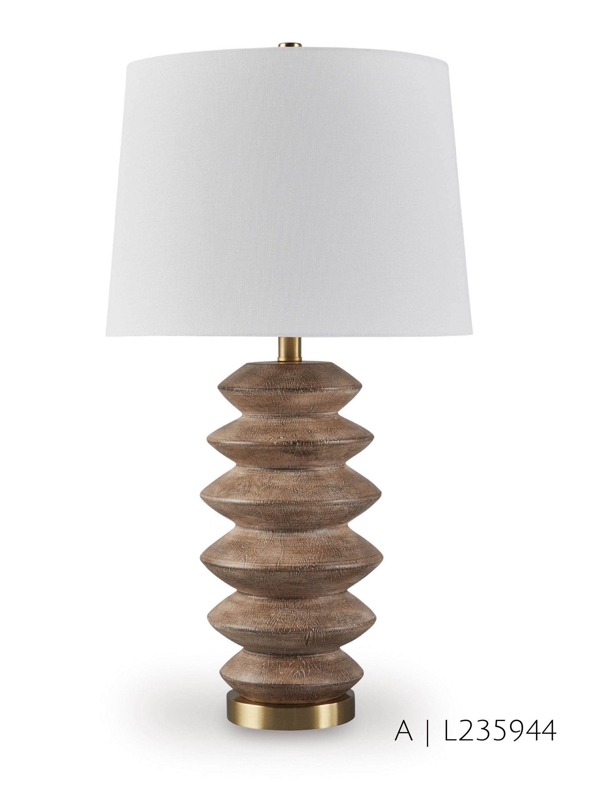 Table lamp with stacked, textured beige base and white shade. Brass accents.