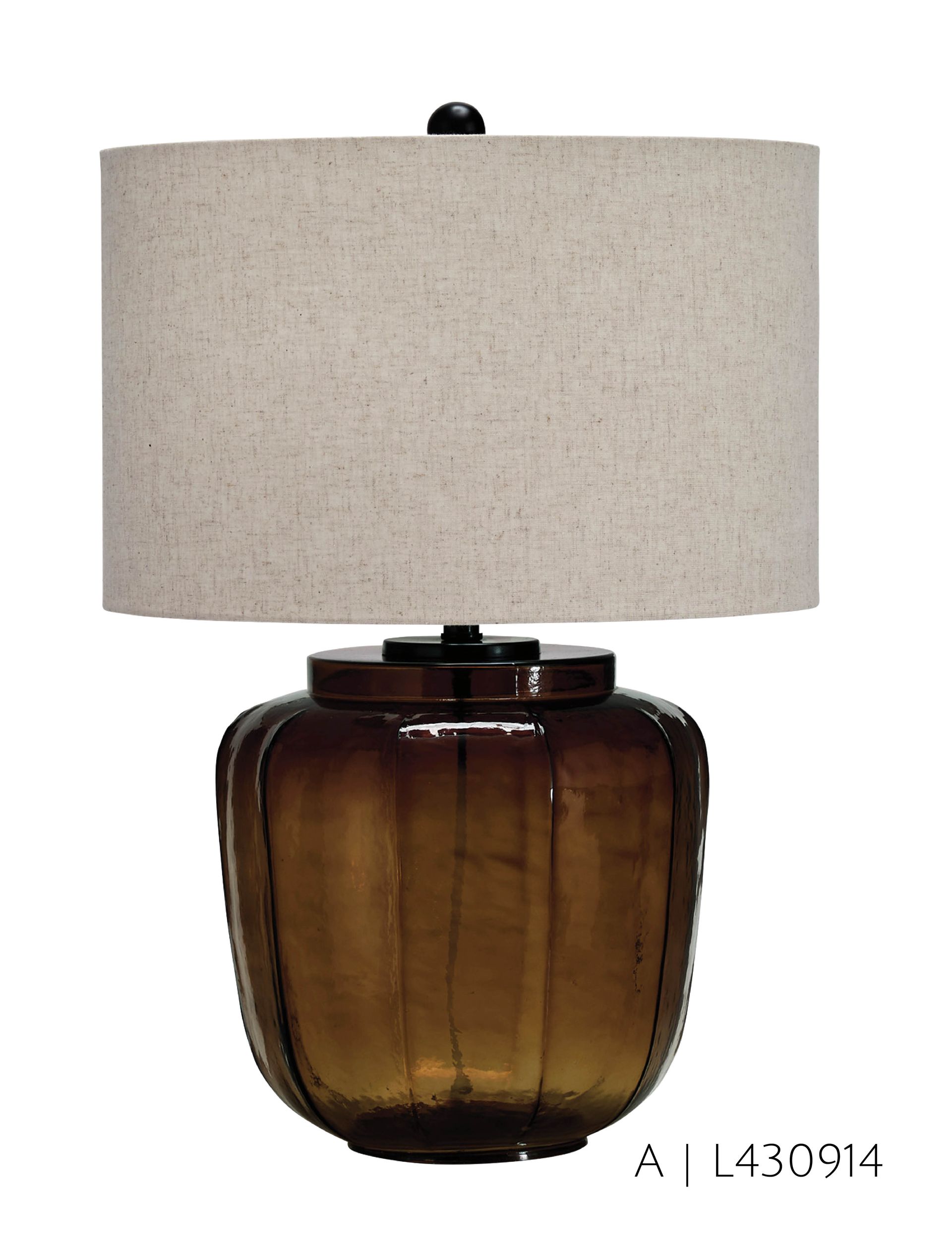 Amber glass table lamp with a beige drum shade.