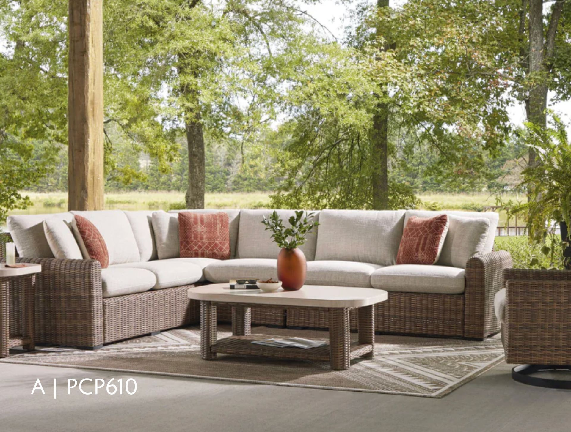 Outdoor sectional sofa with woven brown frame and beige cushions, rustic wooden coffee table on a patio.