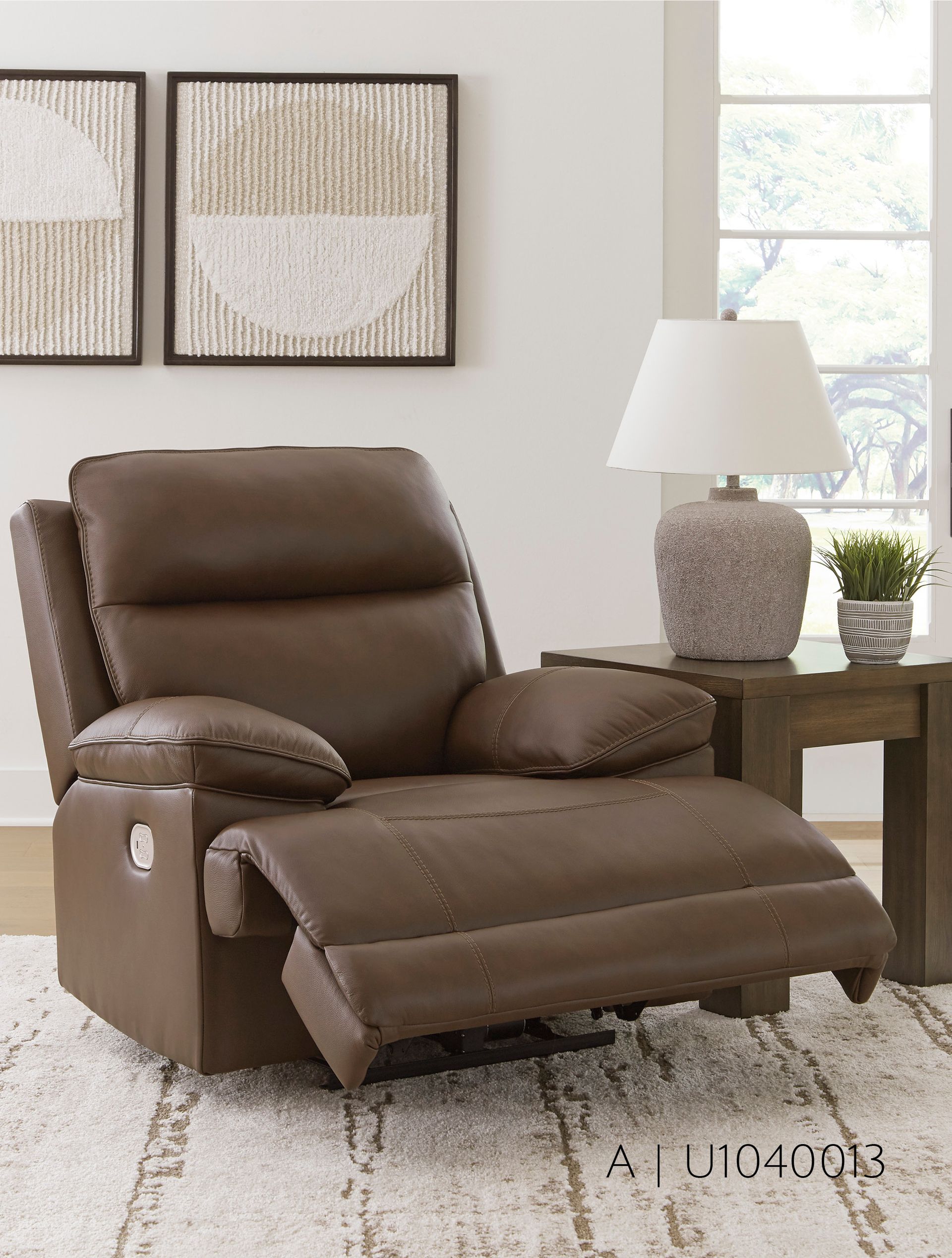 Brown leather recliner in a living room, footrest extended.