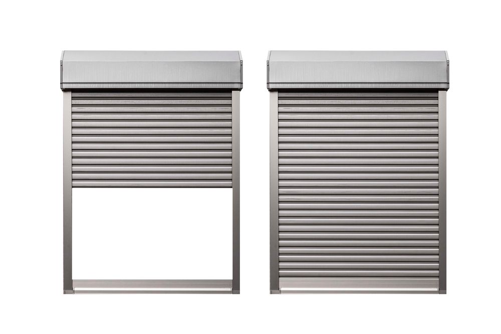 White shutters on a window, slats open. Exterior view with trees and a car visible.