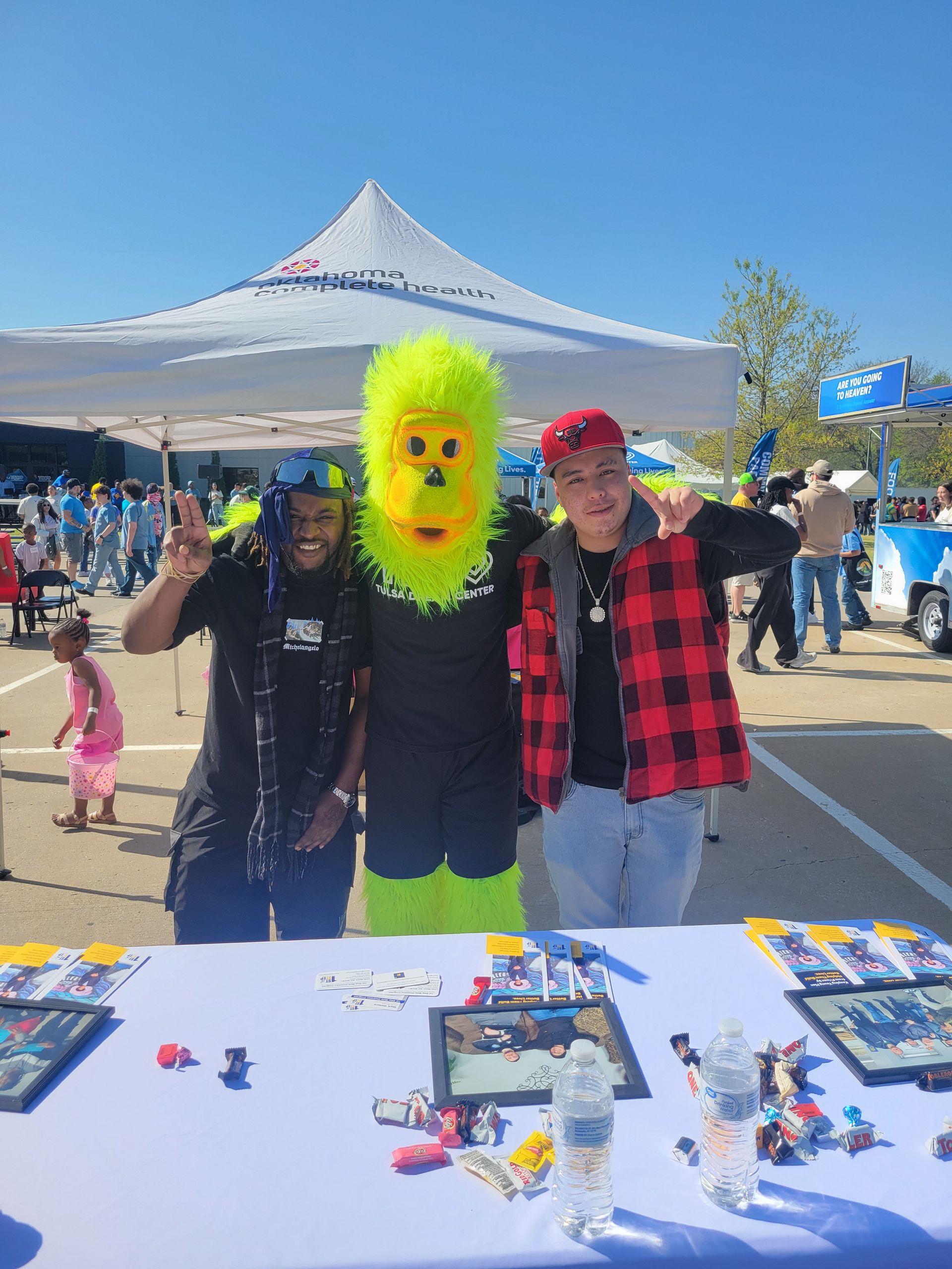A group of people standing next to each other at a table . one of the people is wearing a yellow monkey mask.
