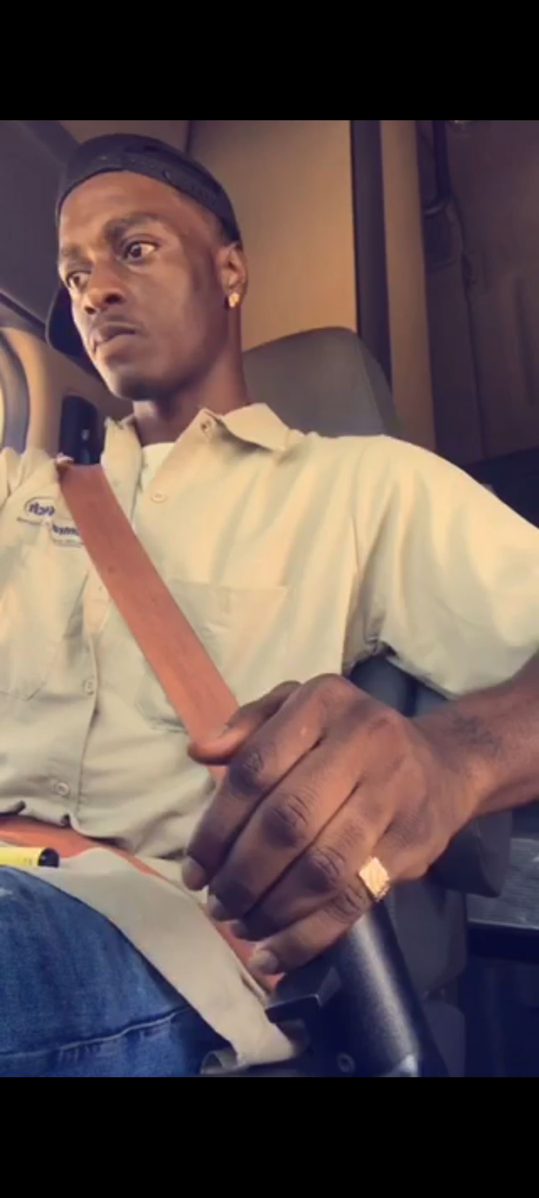A man is sitting in a car adjusting his seat belt