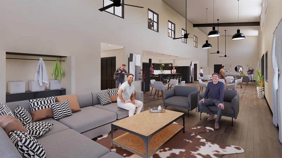 A couple of men are sitting on a couch in a living room.