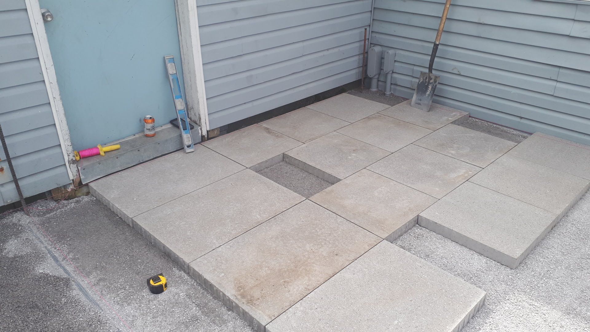 A concrete patio is being built in front of a house.