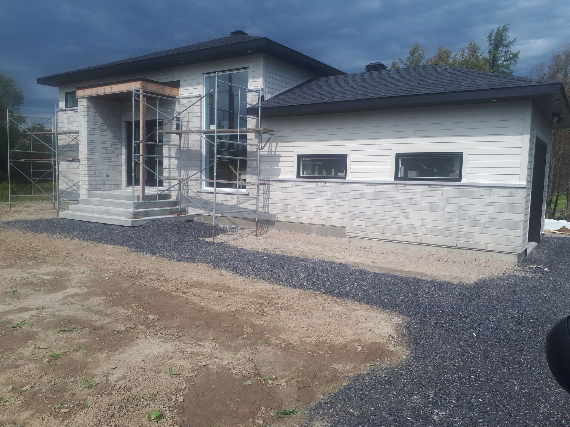 A house is being built in the middle of a dirt field.
