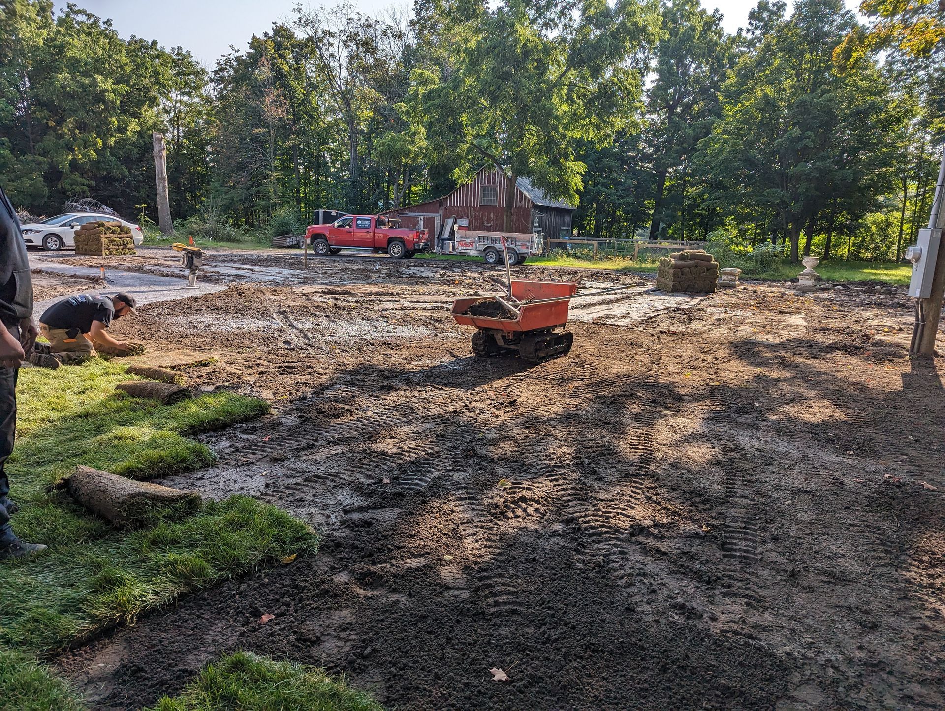 A wheelbarrow is sitting in the middle of a muddy field.