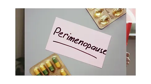 A pink card with the word perimenopause written on it next to a blister pack of pills.