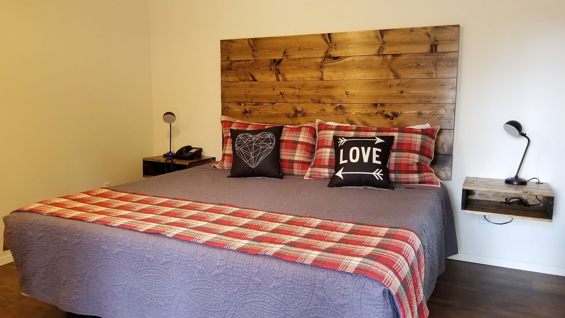 A bed with a wooden headboard and pillows in a bedroom.