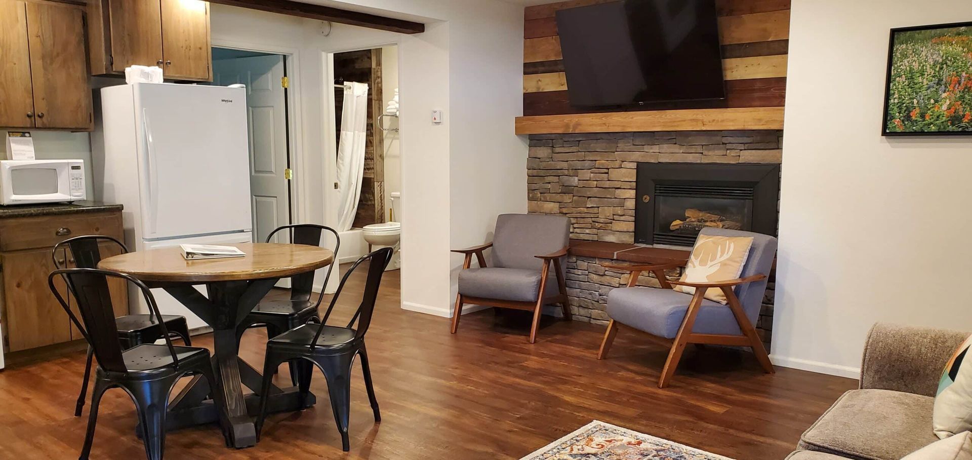 A living room with a table and chairs and a fireplace.