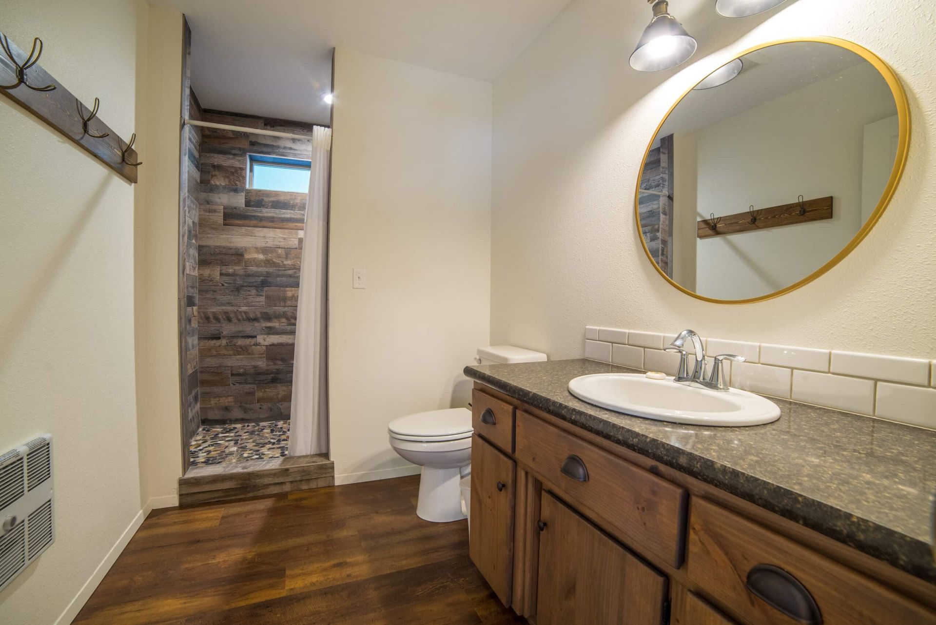 A bathroom with a toilet , sink , and mirror.