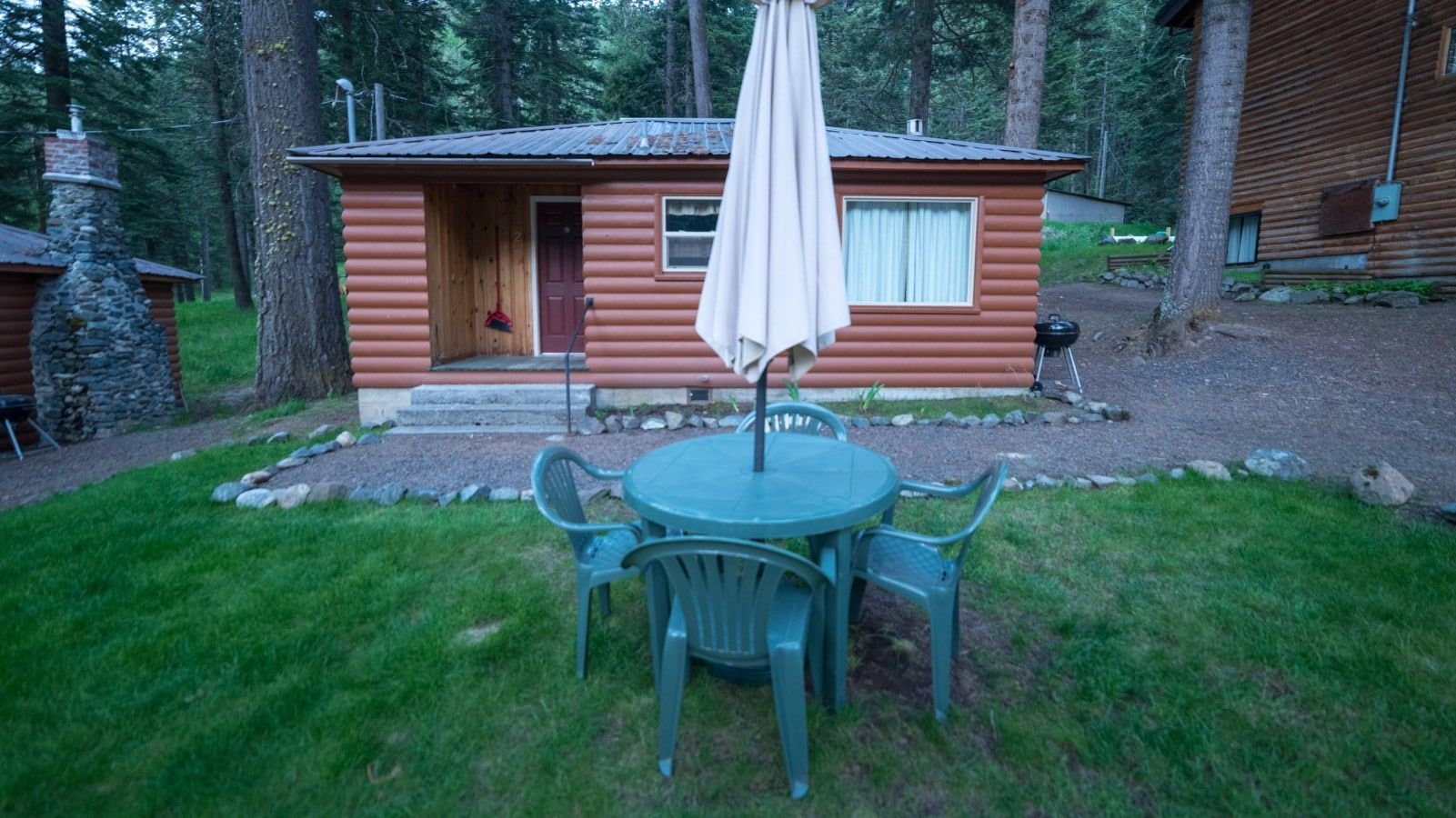 A small cabin with a table and chairs in front of it.