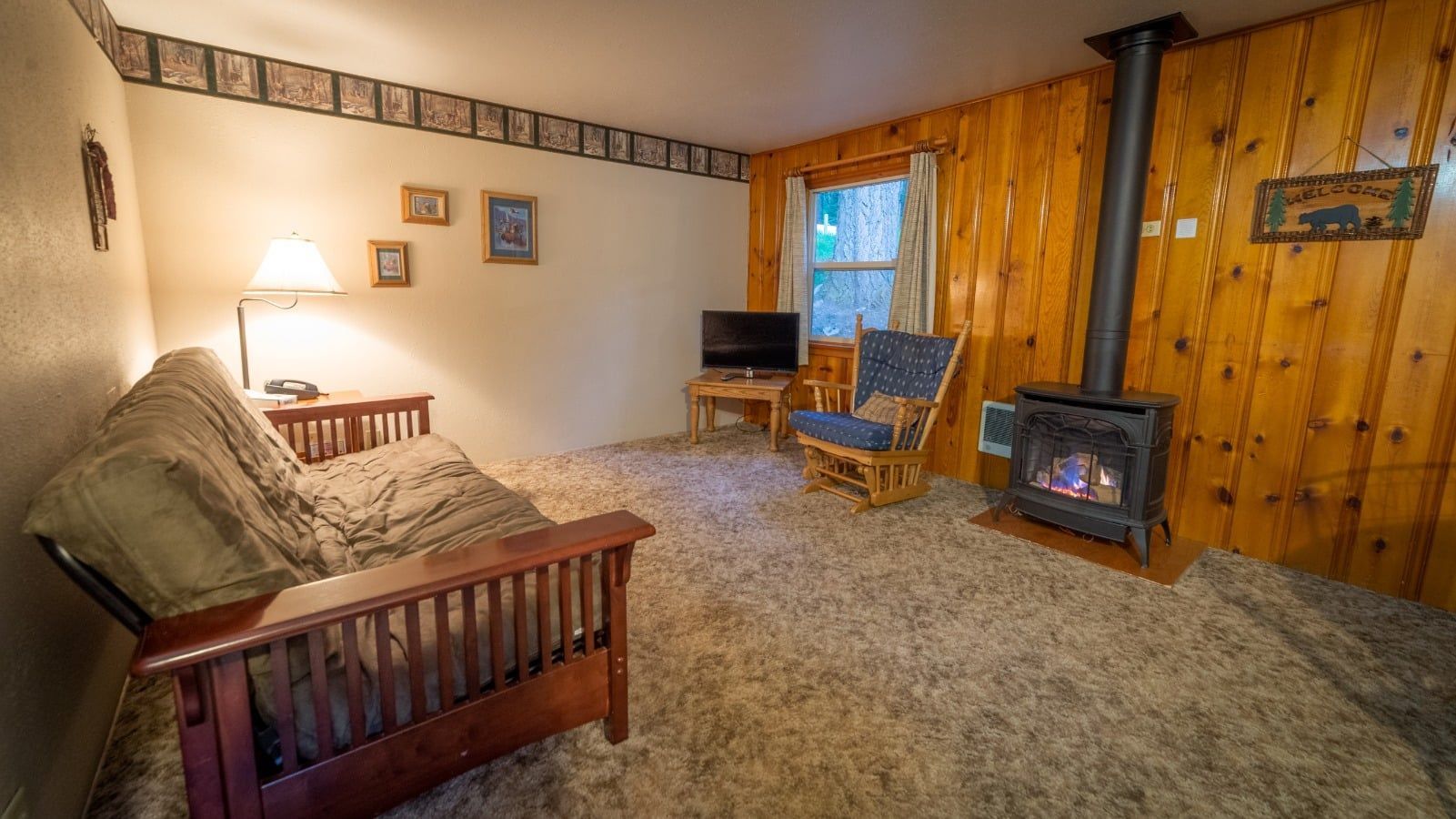 A living room with a couch , chair , fireplace and television.