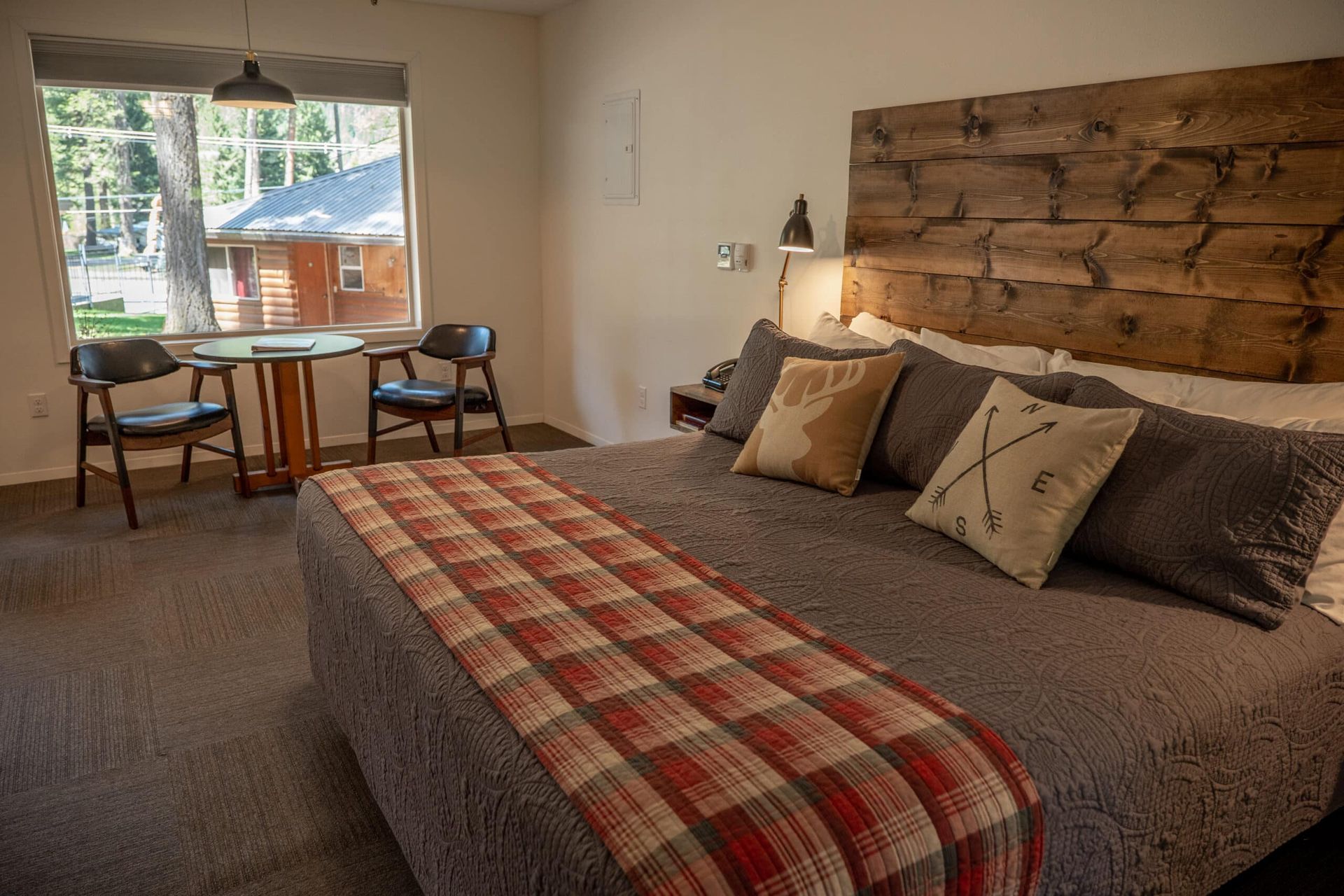 A bedroom with a king size bed , table and chairs.