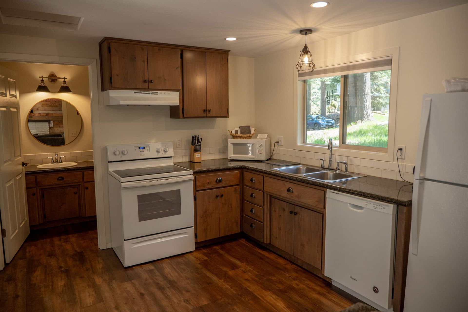 A kitchen with a stove , refrigerator , sink , and microwave.