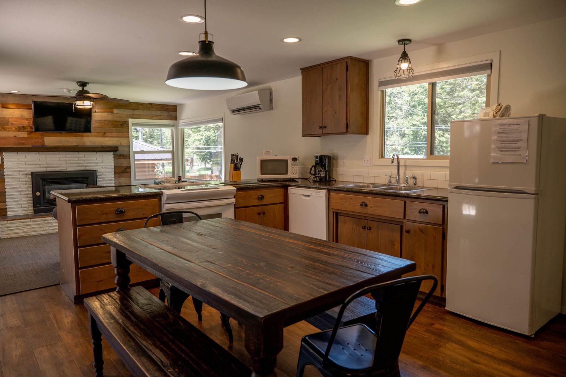 A kitchen with a table , chairs , and a refrigerator.
