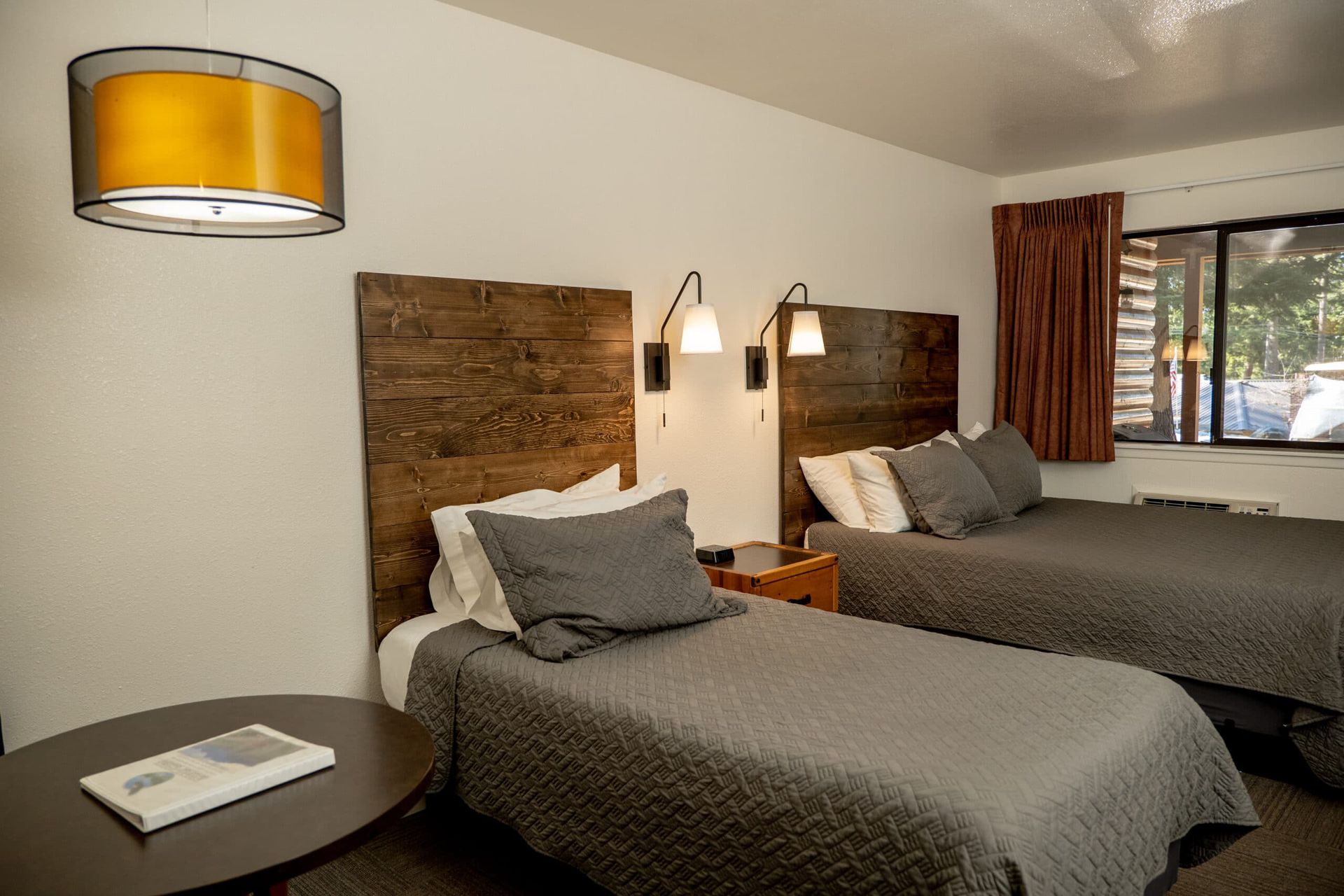 A hotel room with two beds and a table